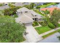 Aerial view showcasing the home's tile roof, well-maintained landscaping, and proximity to a serene lake at 6470 Indigo Bunting Pl, Lakewood Ranch, FL 34202
