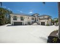 Grand home featuring a spacious driveway, multiple garages, and beautiful architecture against a bright blue sky at 705 89Th Nw Ct, Bradenton, FL 34209