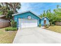 Exterior view of a quaint blue house with a well-maintained lawn and driveway at 7810 34Th E Ct, Sarasota, FL 34243