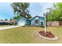 Exterior elevation of a blue one-story house with manicured front yard at 7810 34Th E Ct, Sarasota, FL 34243