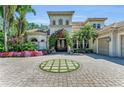 Beautiful home featuring lush landscaping, a brick driveway with a circular grass inlay, and a grand entrance at 8105 Warwick Gardens Ln, University Park, FL 34201