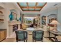 Cozy living room with fireplace and floral accents offers views of screened pool and patio at 8105 Warwick Gardens Ln, University Park, FL 34201