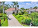 An elevated angle highlighting the residence and the expansive driveway with a manicured lawn and tropical landscaping at 8604 15Th Nw Ave, Bradenton, FL 34209