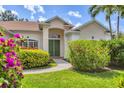 Close-up shot of the home's double door front entrance flanked by vibrant bougainvillea at 8604 15Th Nw Ave, Bradenton, FL 34209