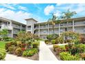 Three-story condo building with garden access and lush green landscaping at 9620 Club South Cir # 5304, Sarasota, FL 34238
