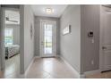 Bright and airy foyer with neutral tones, a glass-paneled door, and tile flooring at 10414 Spring Tide Way, Parrish, FL 34219