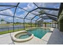 Screened-in pool with spa, lake view, and ample lounging space under a bright blue sky at 11342 77Th E St, Parrish, FL 34219