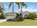 Inviting single story home with a lush green lawn, palm trees, and a welcoming entrance at 12240 Thornhill Ct, Lakewood Ranch, FL 34202