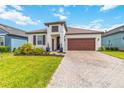 Charming single-story home with a well-manicured lawn and paver driveway leading to a two-car garage at 14314 17Th E Ct, Parrish, FL 34219