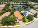 Beautiful aerial view of the home with a private lake, mature landscaping, and a terracotta tile roof at 14325 Stirling Dr, Lakewood Ranch, FL 34202