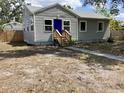 Quaint home featuring a blue front door and a small porch nestled in a cozy front yard at 1512 18Th W Ave, Bradenton, FL 34205