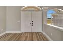 Inviting entryway features double doors, transom window, and wood-look floors at 168 Wading Bird Dr, Venice, FL 34292