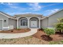 Home's front entrance featuring an elegant double door entry, manicured landscaping, and classic architectural details at 168 Wading Bird Dr, Venice, FL 34292