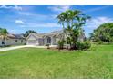 Beautiful one story home with lawn, palm trees, and an attached garage at 168 Wading Bird Dr, Venice, FL 34292