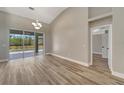 Bright living room with wood floors, sliding glass doors to the pool area, and neutral wall paint at 168 Wading Bird Dr, Venice, FL 34292