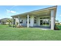 Open backyard patio with large sliding glass doors leading inside, overlooking a lush green lawn at 17719 Palmiste Dr, Bradenton, FL 34202
