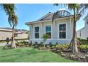 Bright single story home featuring manicured landscaping, including palm trees and flowering plants at 17719 Palmiste Dr, Bradenton, FL 34202
