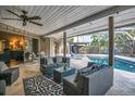 Covered patio with comfortable seating overlooking a sparkling pool surrounded by lush landscaping at 1809 Buccaneer Ter, Sarasota, FL 34231