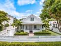 Charming two-story home with a white picket fence, mature landscaping, and a welcoming curb appeal at 1841 Datura St, Sarasota, FL 34239