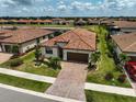 Community aerial view featuring a home with a red tile roof and paver driveway at 20542 Trattoria Loop, Venice, FL 34293
