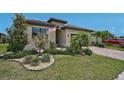 A well-manicured front yard with green grass, landscaping, and brick paver driveway at 20542 Trattoria Loop, Venice, FL 34293