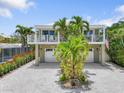 Inviting home with double garage, mature landscaping, and a cozy balcony, perfect for relaxation at 229 S Harbor Dr, Holmes Beach, FL 34217