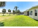 Expansive backyard with lush green lawn, mature palm trees, and screened-in lanai at 315 Heritage Isles Way, Bradenton, FL 34212