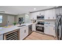 Modern kitchen with stainless steel appliances, white cabinets, quartz countertops, and hardwood floors at 3193 Bellevue St, Sarasota, FL 34237