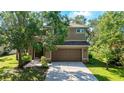 Attractive two-story home with an attached garage and well-maintained lawn, framed by mature trees at 3303 Pine Top Dr, Valrico, FL 33594