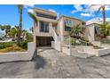 Modern condo featuring covered parking, a stairway to the front door, and lush tropical landscaping at 3803 E Bay Dr # 10, Bradenton Beach, FL 34217