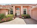 Home's entrance with double doors, transom window, and landscaped pathway leading to the front entrance at 431 Fieldstone Dr, Venice, FL 34292