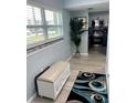 Hallway with wood floors, beach-themed bench, palm tree and view of the kitchen at 4511 3Rd Street W Cir # 289, Bradenton, FL 34207