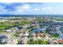 Beautiful aerial view of a community with a scenic pond, lush greenery, and blue skies at 5320 Layton Dr, Venice, FL 34293