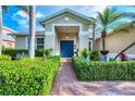 Inviting front entrance with a blue door, brick pathway, and well-maintained landscaping at 5320 Layton Dr, Venice, FL 34293