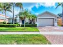 Inviting home exterior with a brick driveway, lush lawn, and manicured hedges at 5320 Layton Dr, Venice, FL 34293
