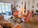 Comfortable living room featuring a floral sofa and two pink upholstered chairs at 5895 17Th W St # B-26, Bradenton, FL 34207