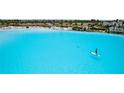 Aerial view of a pristine lagoon with crystal-clear turquoise water and a paddle boarder at 5910 Red Mangrove Ln, Bradenton, FL 34210