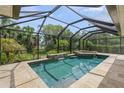 Enclosed pool and spa area, complete with a waterfall feature and lush tropical landscaping at 6664 Deering Cir, Sarasota, FL 34240