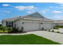 Beige home featuring a two-car garage and lush, green front lawn at 16234 Isola Pl, Bradenton, FL 34211