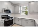 Close up of kitchen with gray cabinets, stainless appliances, and white subway tile at 16234 Isola Pl, Bradenton, FL 34211