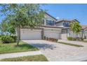 Charming home featuring a brick driveway, two-car garage, and manicured landscaping at 18113 Gawthrop Drive # 101, Lakewood Ranch, FL 34211