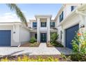 Beautiful two-story home featuring a stylish entrance, blue shutters, lush landscaping, and a two-car garage at 18215 Cayo Largo Pl, Bradenton, FL 34202