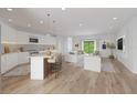 Bright open-concept living room and kitchen area with hardwood floors and modern decor at 2141 Cork Oak St, Sarasota, FL 34232
