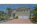 Inviting two-story home featuring a brick driveway and a two-car garage at 220 36Th St, Holmes Beach, FL 34217