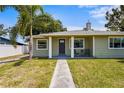 Traditional home with a manicured lawn and cozy seating on the covered front porch at 3102 16Th W Ave, Bradenton, FL 34205