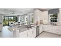 Bright, modern kitchen with white cabinetry, stainless steel appliances, and a spacious island open to the living area at 3118 Torta Ct, Bradenton, FL 34211