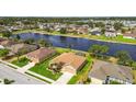 Aerial view of a lakeside home featuring lush landscaping, a large backyard, and neighborhood at 327 64Th Avenue E Cir, Bradenton, FL 34203