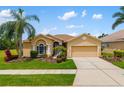 Inviting single-story home featuring lush landscaping, a two-car garage, and an arched entryway at 370 Londonderry Dr, Sarasota, FL 34240