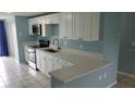 Modern kitchen featuring stainless steel appliances, white cabinets, and stone countertops at 4304 78Th W St # 4304, Bradenton, FL 34209