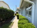 Well-maintained property with green bushes lining a walkway and ample sunlight at 4613 Muirfield Dr, Bradenton, FL 34210